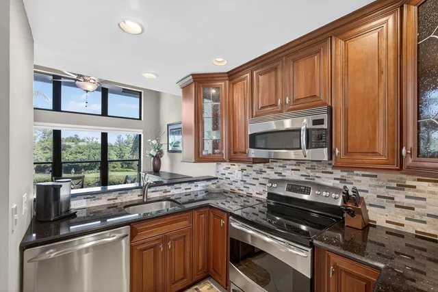 a kitchen with stainless steel appliances granite countertop a stove top oven a sink and a microwave
