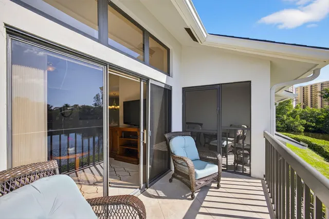 a balcony with furniture and a floor to ceiling window