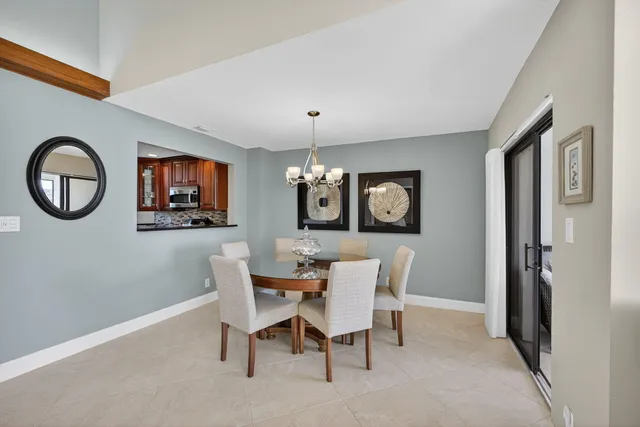 a dining room with furniture a chandelier and wooden floor
