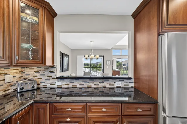 a kitchen with stainless steel appliances granite countertop a refrigerator and a stove top oven