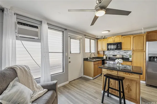 a kitchen with stainless steel appliances granite countertop a stove top oven a refrigerator a sink with island and chairs