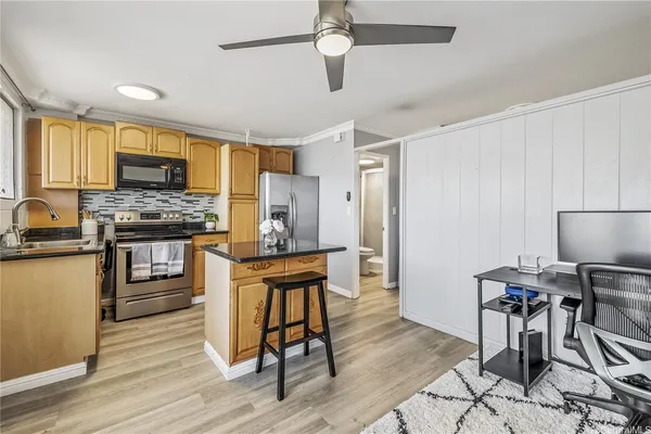 a kitchen with granite countertop a stove a sink and a refrigerator