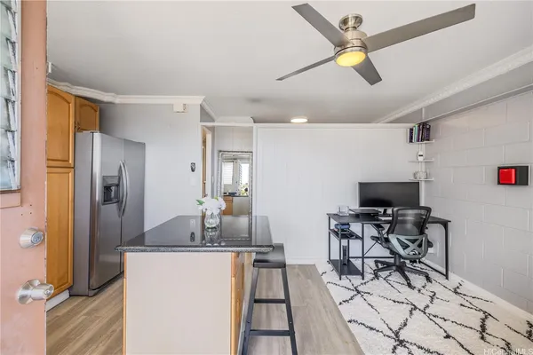 a kitchen with stainless steel appliances kitchen island granite countertop a refrigerator a stove a microwave oven with a dining table and chairs with wooden floor