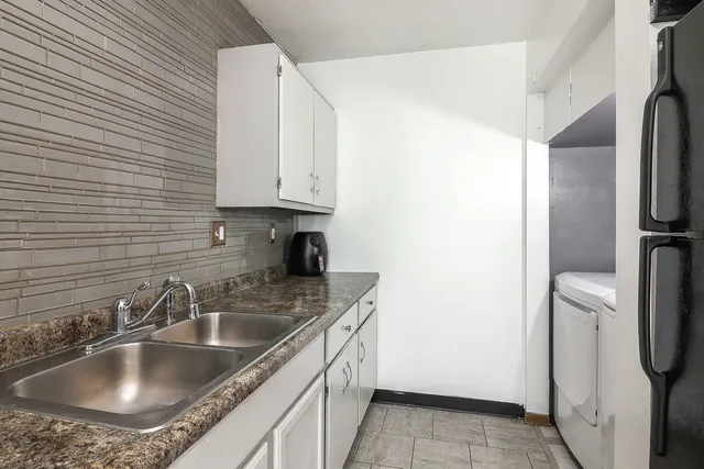 a kitchen with a sink refrigerator and cabinets