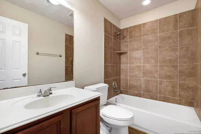 a bathroom with a bathtub shower sink mirror and toilet