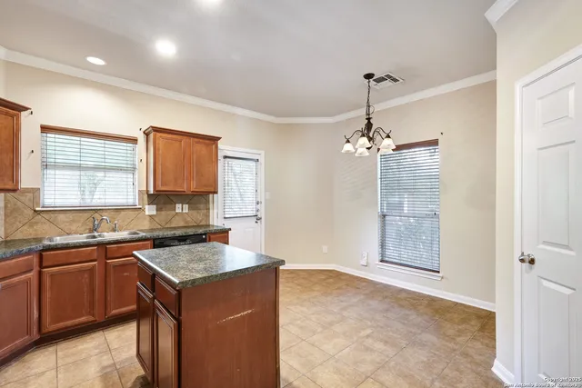 a kitchen that has a sink a window and cabinets