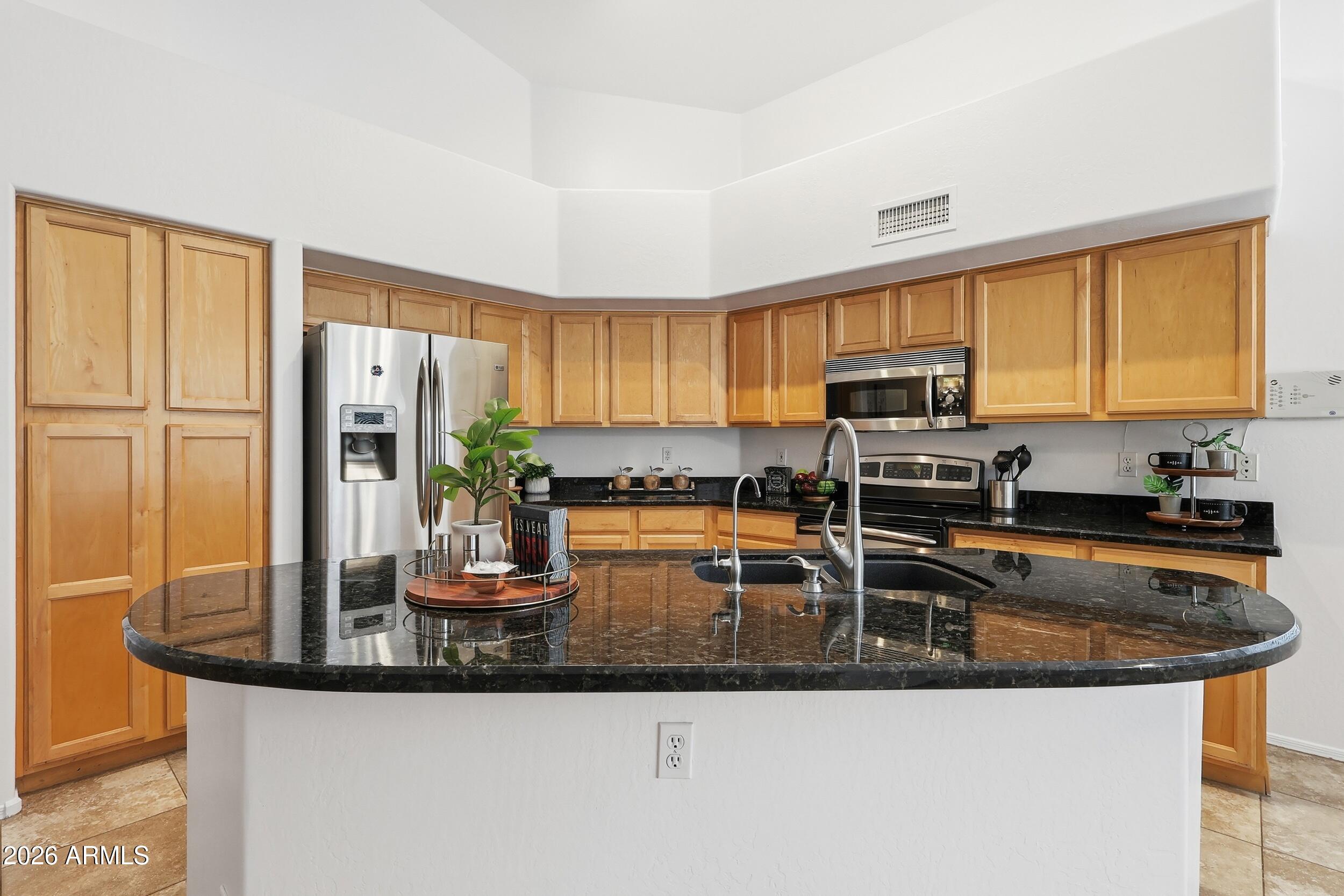 5377 West Jupiter Way Chandler, AZ 85226 - Photo 11 of 49 a kitchen with granite countertop a sink stove and refrigerator