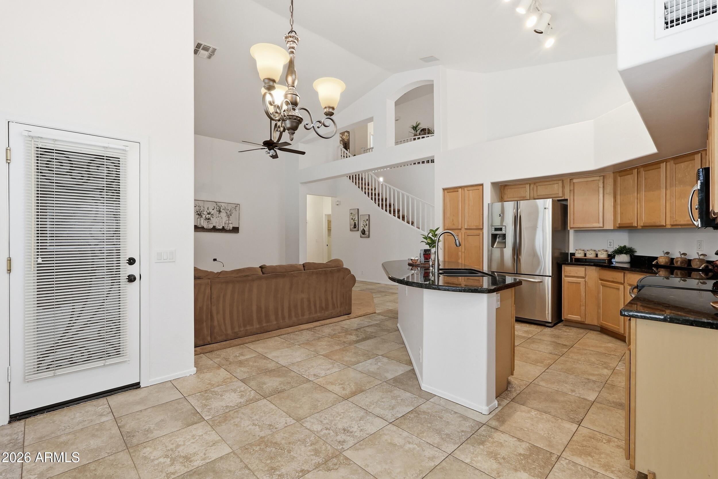 5377 West Jupiter Way Chandler, AZ 85226 - Photo 9 of 49 a kitchen with kitchen island granite countertop a refrigerator a stove a oven and a sink