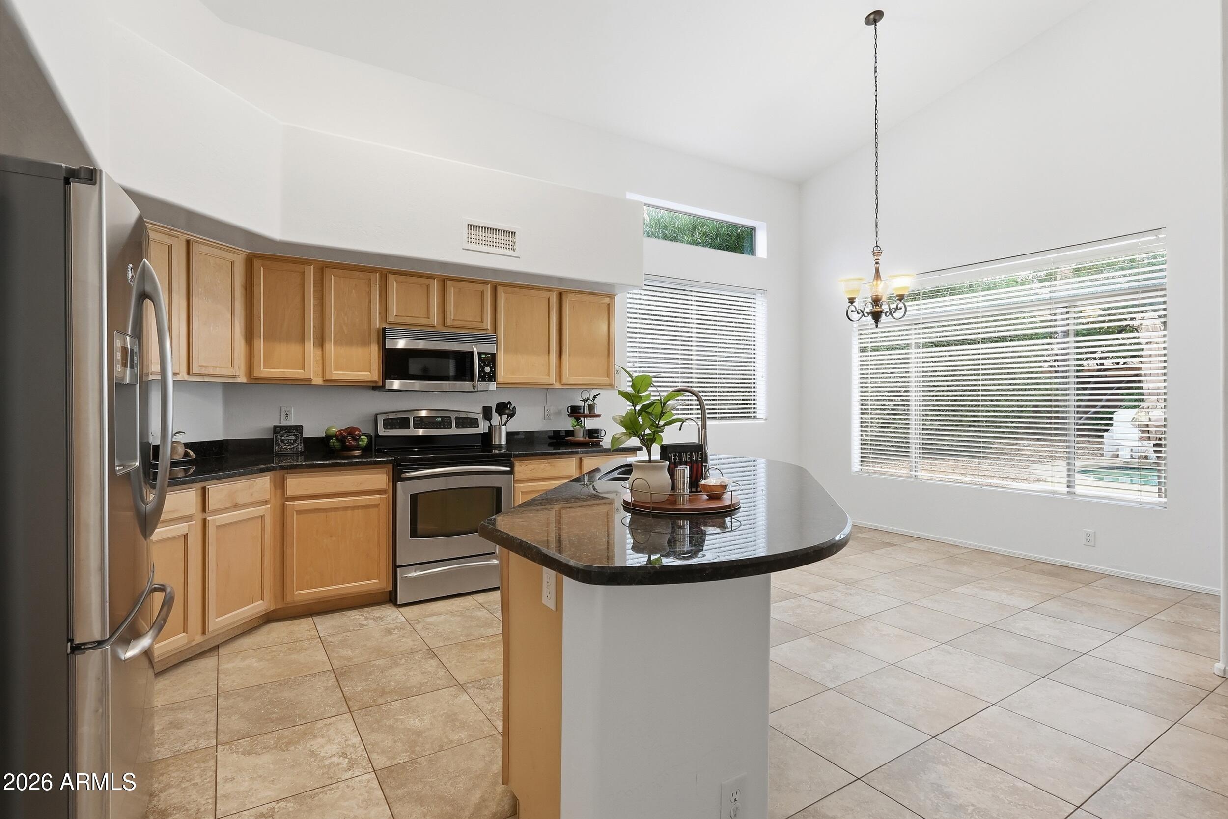 5377 West Jupiter Way Chandler, AZ 85226 - Photo 10 of 49 a kitchen with granite countertop a stove a sink and a granite counter tops
