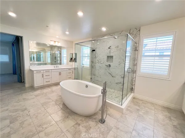 a spacious bathroom with a large tub shower and sink