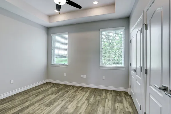 a view of an empty room with a window and wooden floor