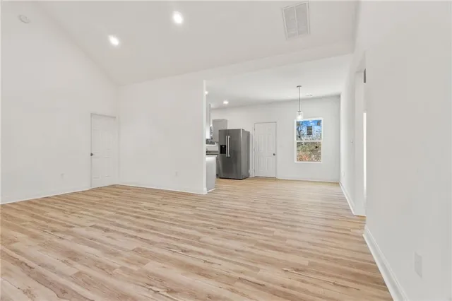 a view of empty room with wooden floor