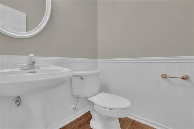 a bathroom with a sink a toilet and a mirror