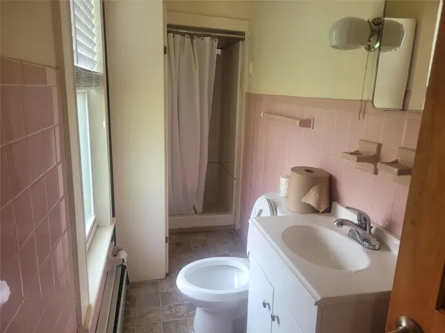 a bathroom with a sink toilet and a mirror