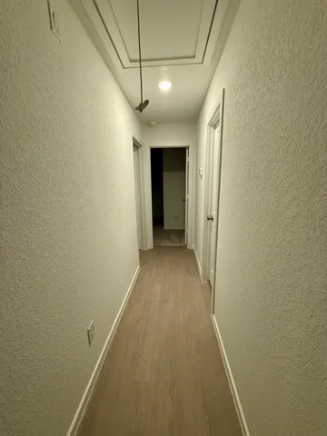 a view of a hallway with wooden floor