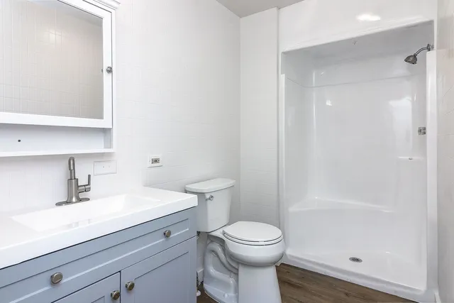 a bathroom with a sink a toilet and shower