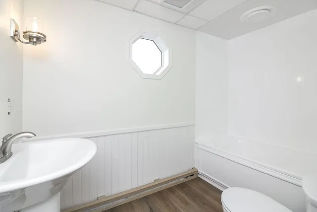 a bathroom with a toilet a sink and mirror