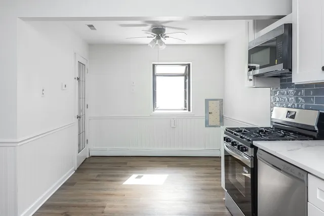 a kitchen with stainless steel appliances a stove a microwave and cabinets