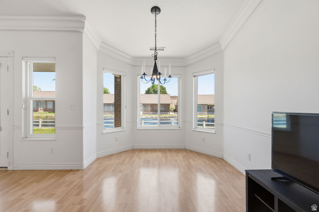 805 South River Road, Unit 70 St. George, UT 84790 - Photo 8 of 38 Bay window dining area featuring a black chandelier, crown molding, chair rail molding, and wood-finish flooring