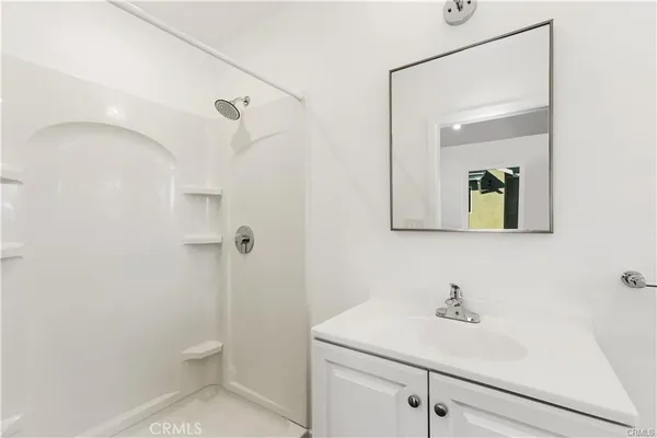 a bathroom with a granite countertop sink a toilet and mirror