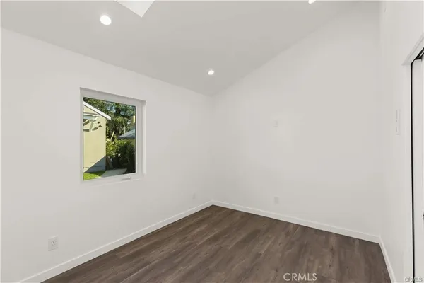 an empty room with wooden floor and a window