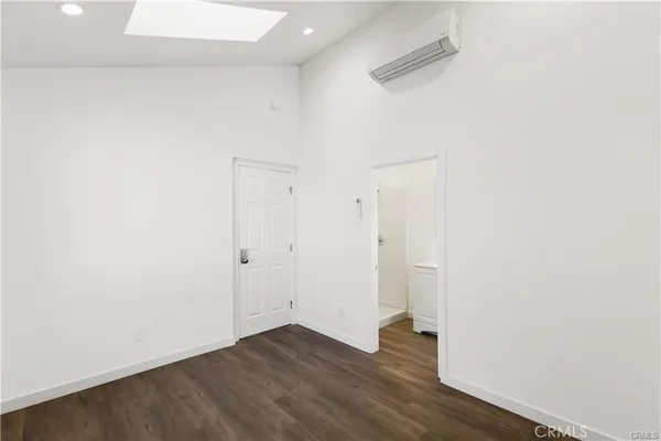 a view of an empty room with wooden floor and closet