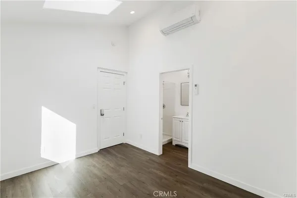 a view of an empty room with wooden floor and closet