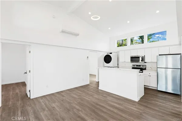 a view of a kitchen with a refrigerator wooden floor and a ceiling fan