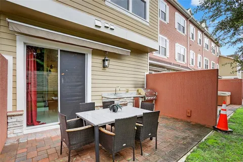 a backyard of a house with barbeque oven table and chairs