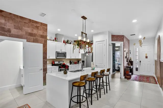 a kitchen with stainless steel appliances kitchen island granite countertop a refrigerator and a sink