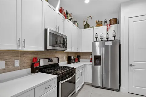 a kitchen with stainless steel appliances granite countertop a refrigerator sink stove and microwave