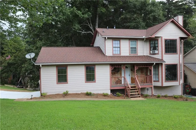 a front view of a house with a garden and trees