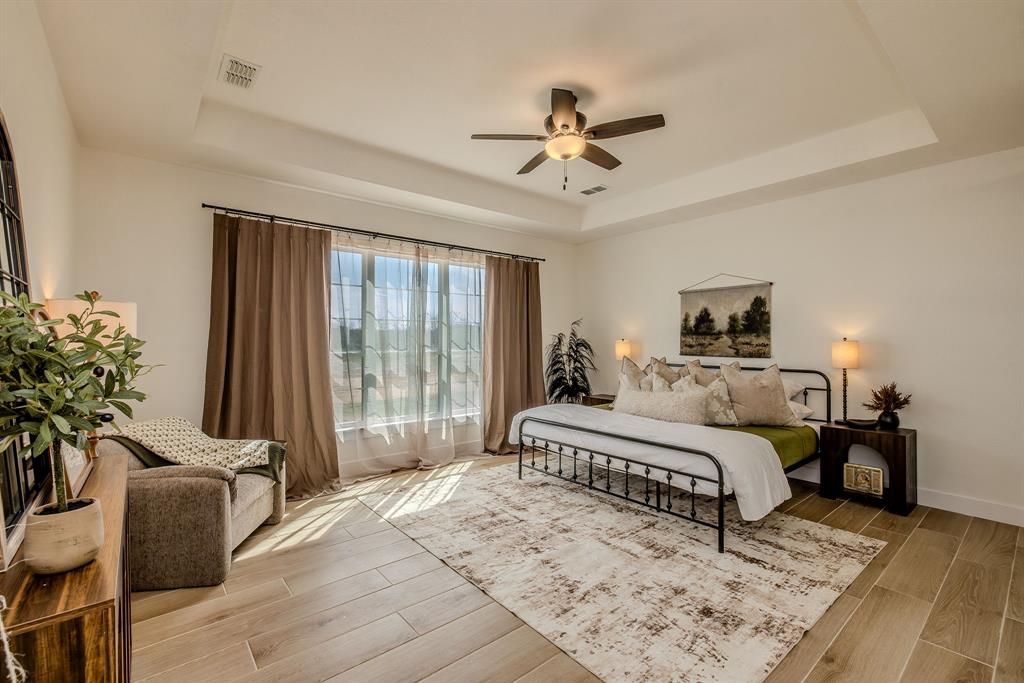 2847 Canyon Wren Loop Graford, TX 76449 - Photo 22 of 40 a spacious bedroom with a bed a chandelier and glass door