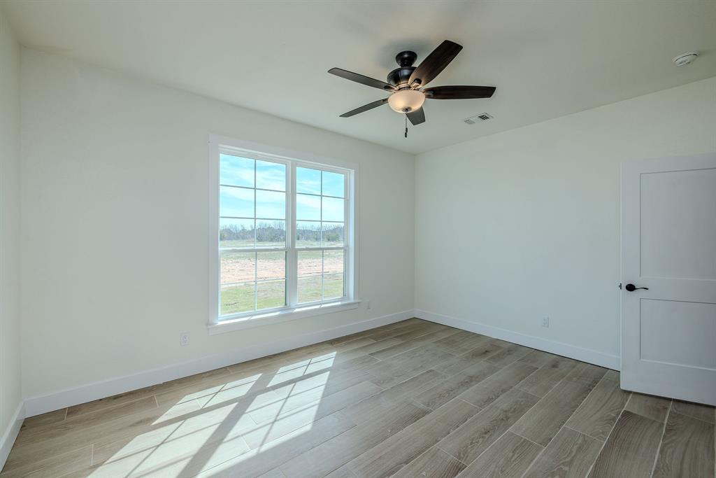 2847 Canyon Wren Loop Graford, TX 76449 - Photo 30 of 40 an empty room with wooden floor fan and windows