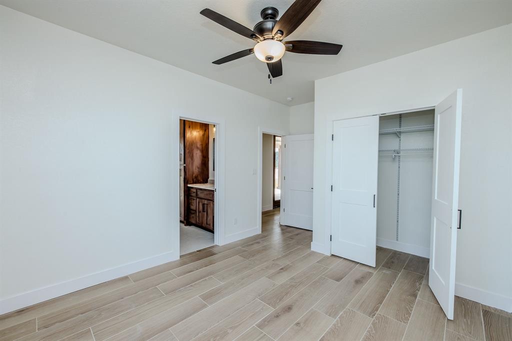 2847 Canyon Wren Loop Graford, TX 76449 - Photo 33 of 40 an empty room with wooden floor and a ceiling fan