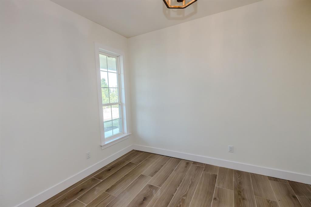 2847 Canyon Wren Loop Graford, TX 76449 - Photo 5 of 40 an empty room with wooden floor and windows
