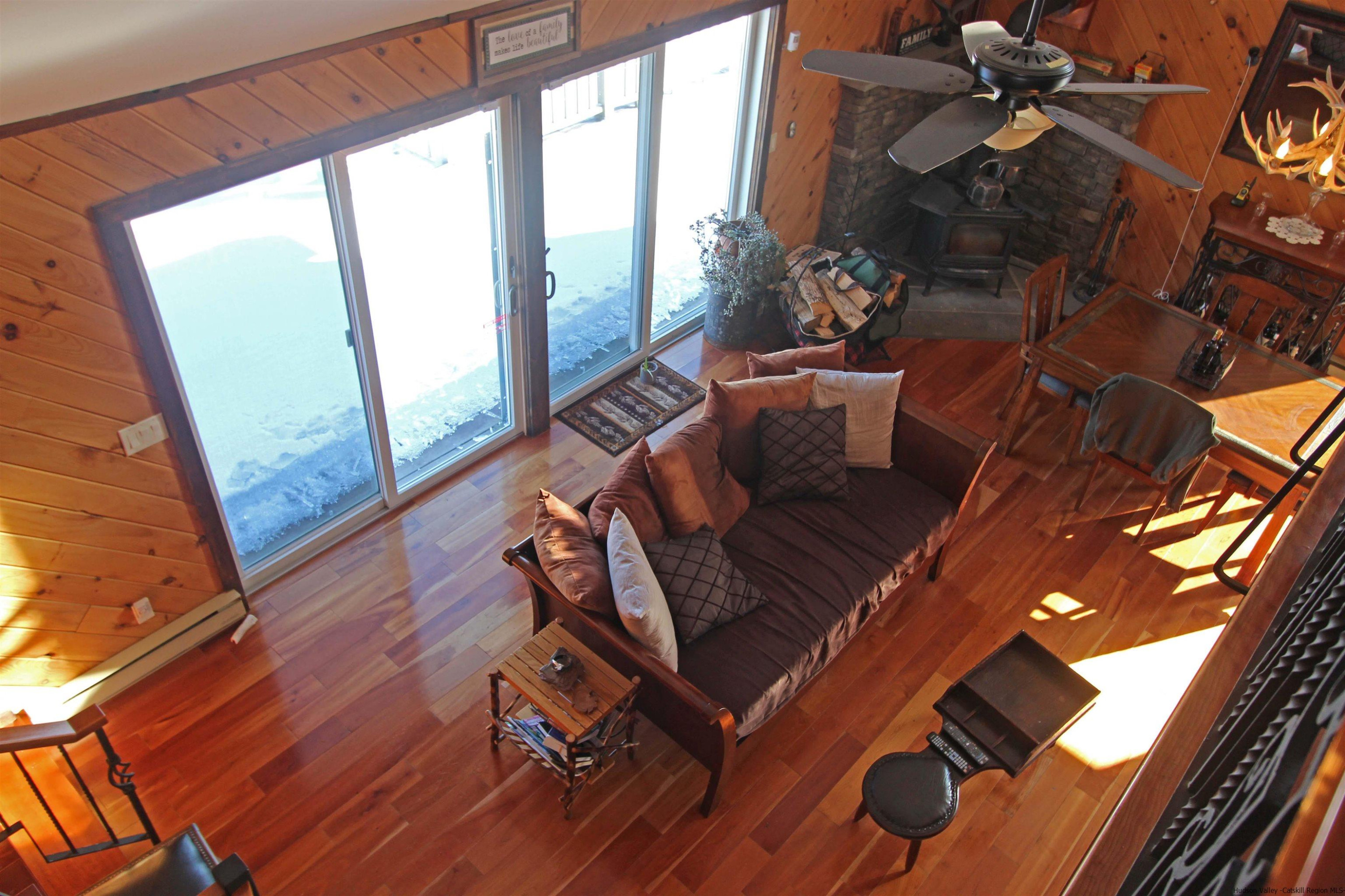 143 Rossman Road Roxbury, NY 12421 - Photo 21 of 35 a living room with couches bookshelf and a large window with wooden floor