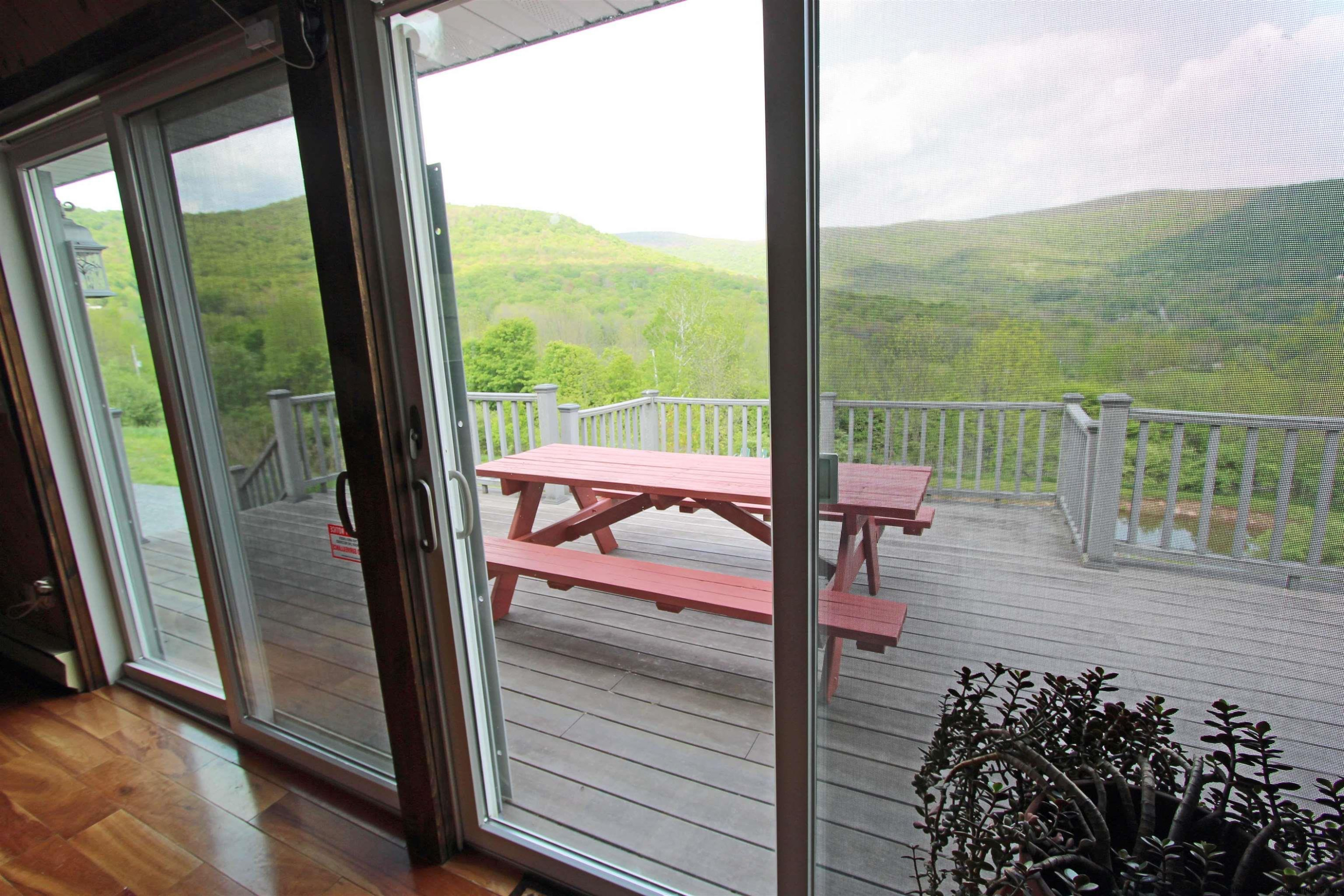 143 Rossman Road Roxbury, NY 12421 - Photo 22 of 35 a view of a balcony with floor to ceiling windows with wooden floor