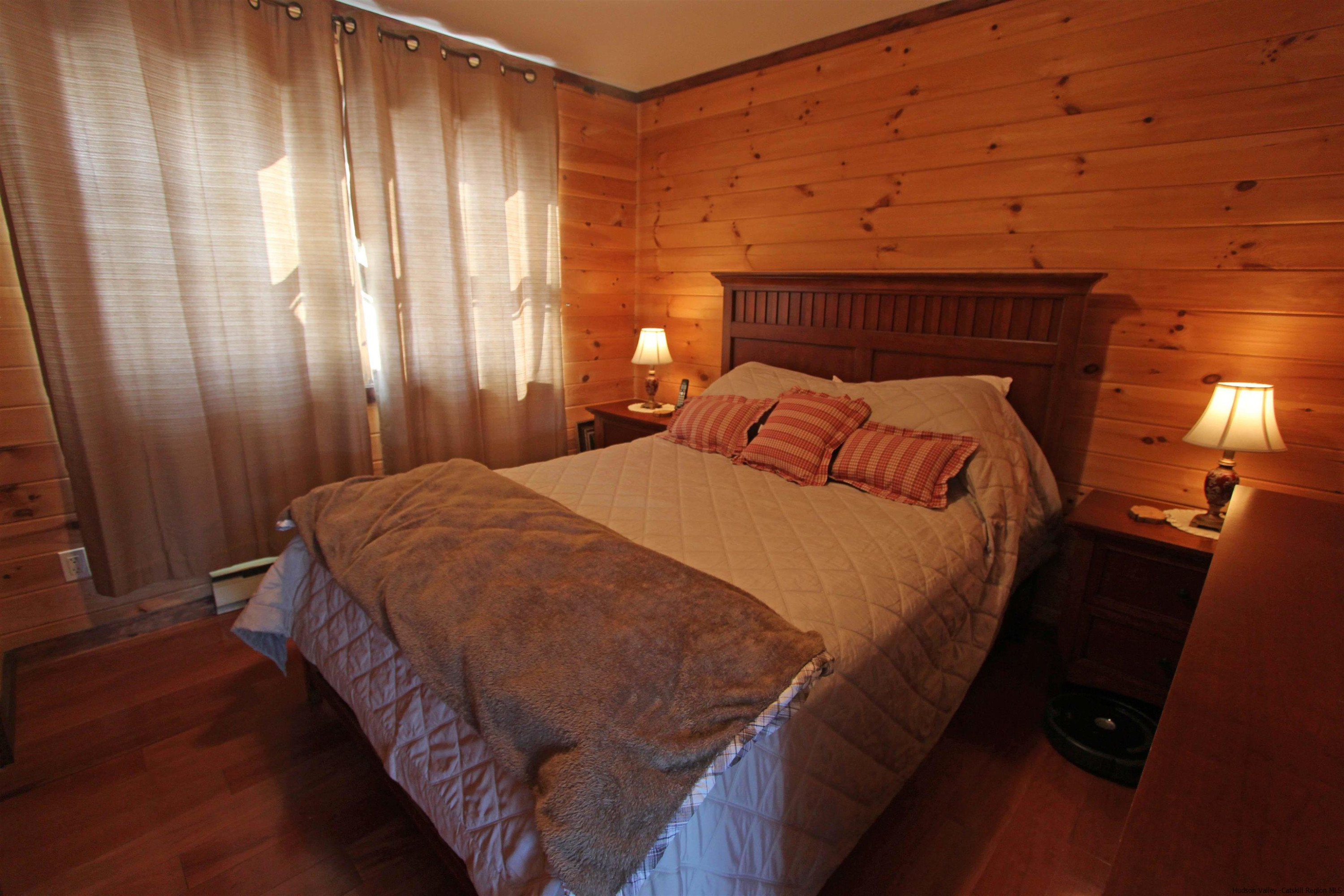 143 Rossman Road Roxbury, NY 12421 - Photo 23 of 35 a bedroom with a bed and wooden floor