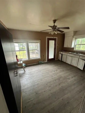 an empty room with windows and ceiling fan