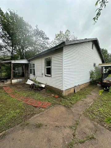 a backyard of a house with barbeque oven table and chairs