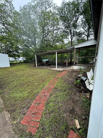 a view of a backyard with floor to ceiling window and wooden fence