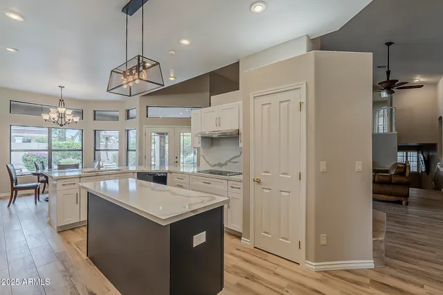 a kitchen with stainless steel appliances granite countertop a sink a stove a refrigerator cabinets and a counter top space