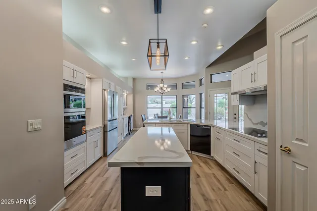 a kitchen with a sink dishwasher a stove and a refrigerator with wooden floor