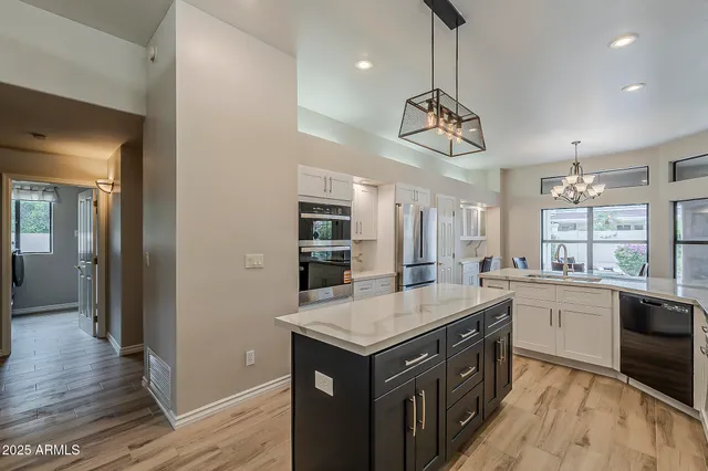 a kitchen with stainless steel appliances granite countertop a sink refrigerator and cabinets