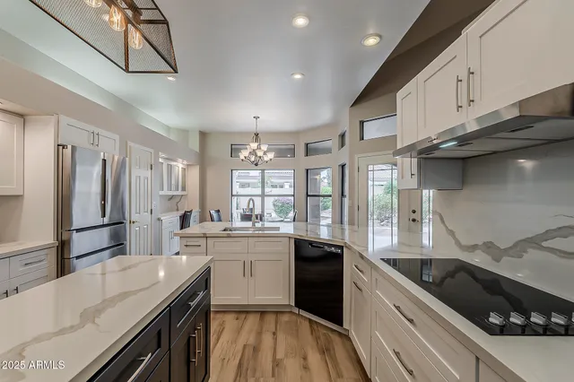 a kitchen with stainless steel appliances kitchen island granite countertop a refrigerator and a stove top oven