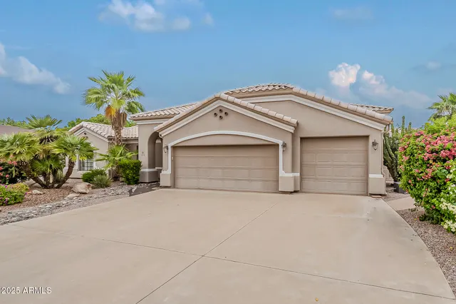 a front view of a house with a yard and a garage