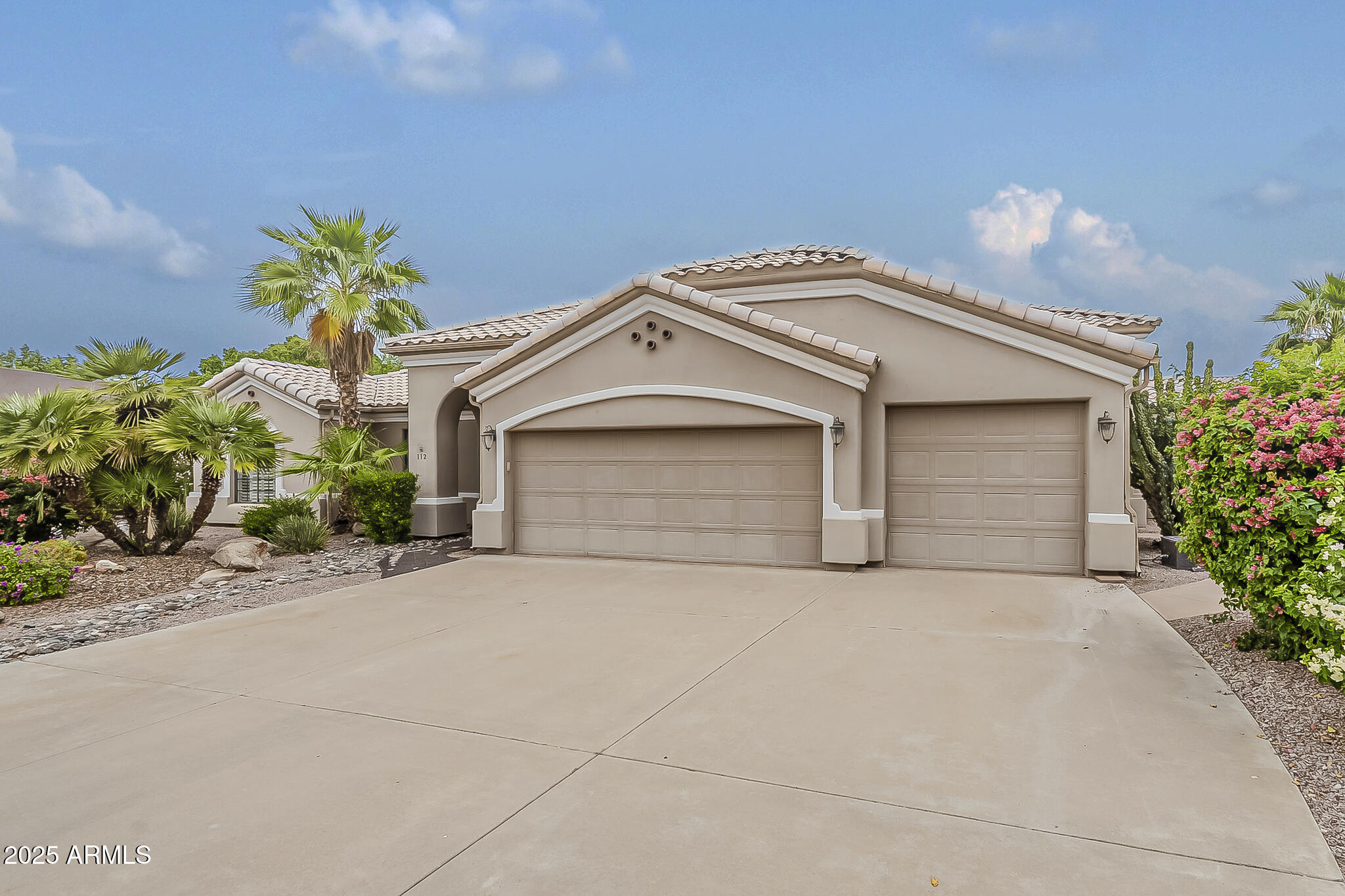 5345 East McLellan Road, Unit 112 Mesa, AZ 85205 - Photo 2 of 74 a front view of a house with a yard and a garage