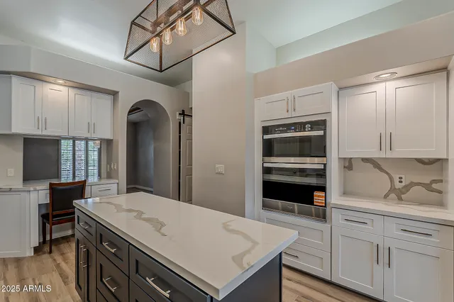 a kitchen with stainless steel appliances kitchen island granite countertop a refrigerator and a sink