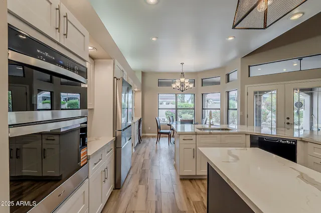 a view of a dining room with furniture a chandelier and wooden floor
